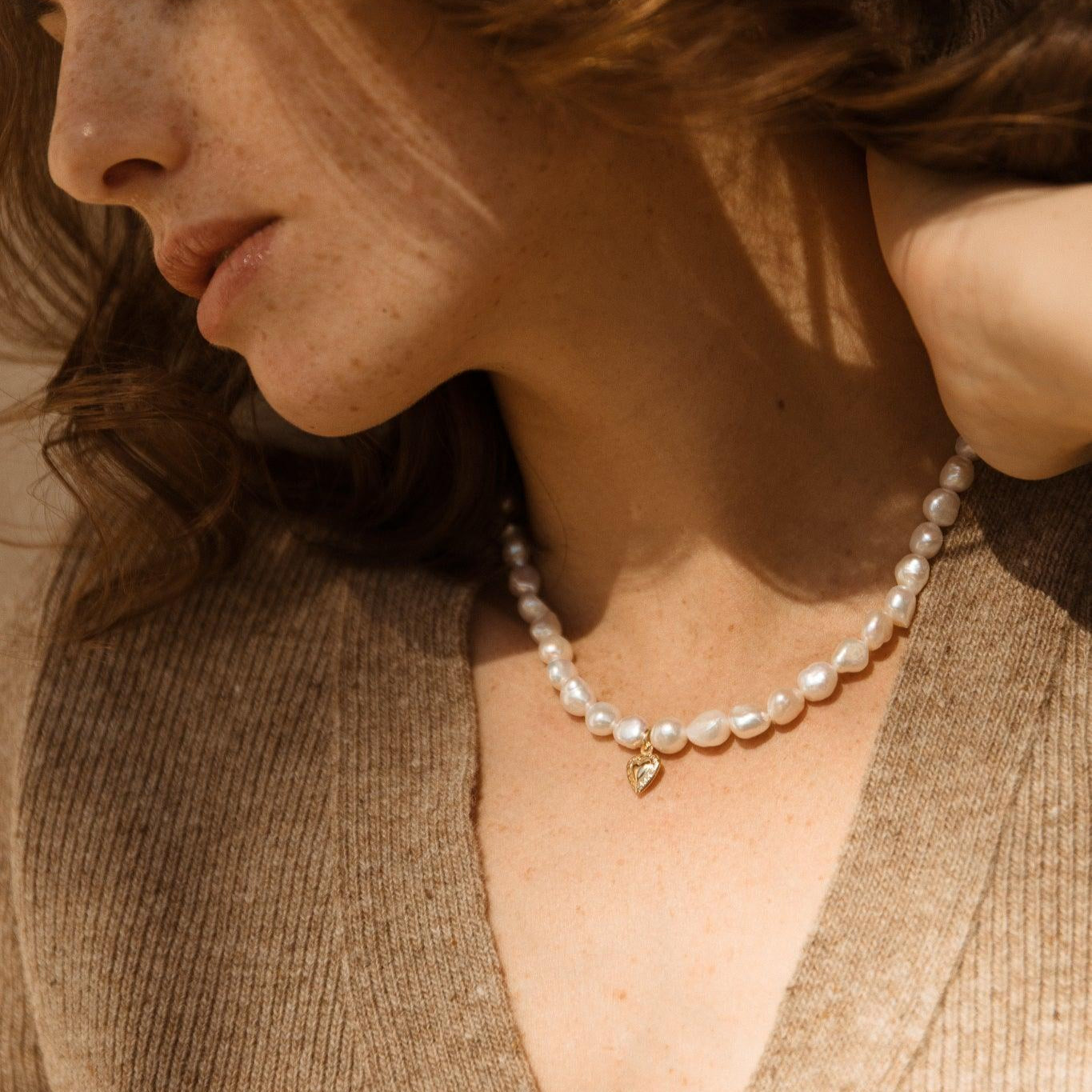 Collier Hannah en perles de culture et cœur doré vu de profil, style romantique et artisanal. Idée cadeau femme ou ado.