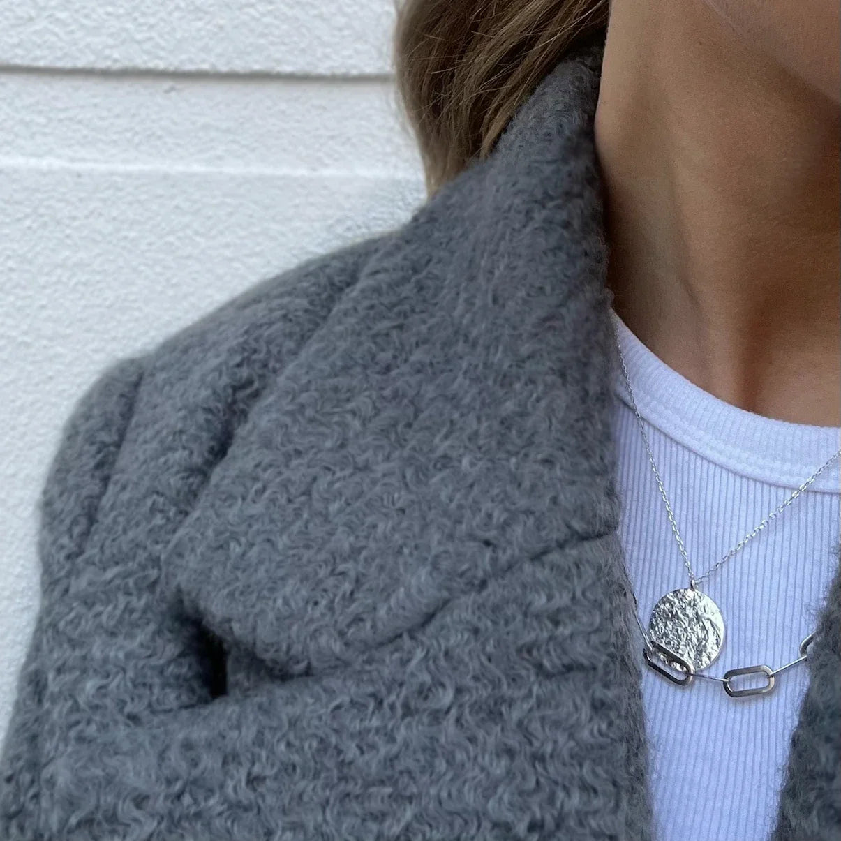 Collier vintage style carte ancienne porté avec un manteau en laine gris. collier atlas love local jewelry. Koolkado.