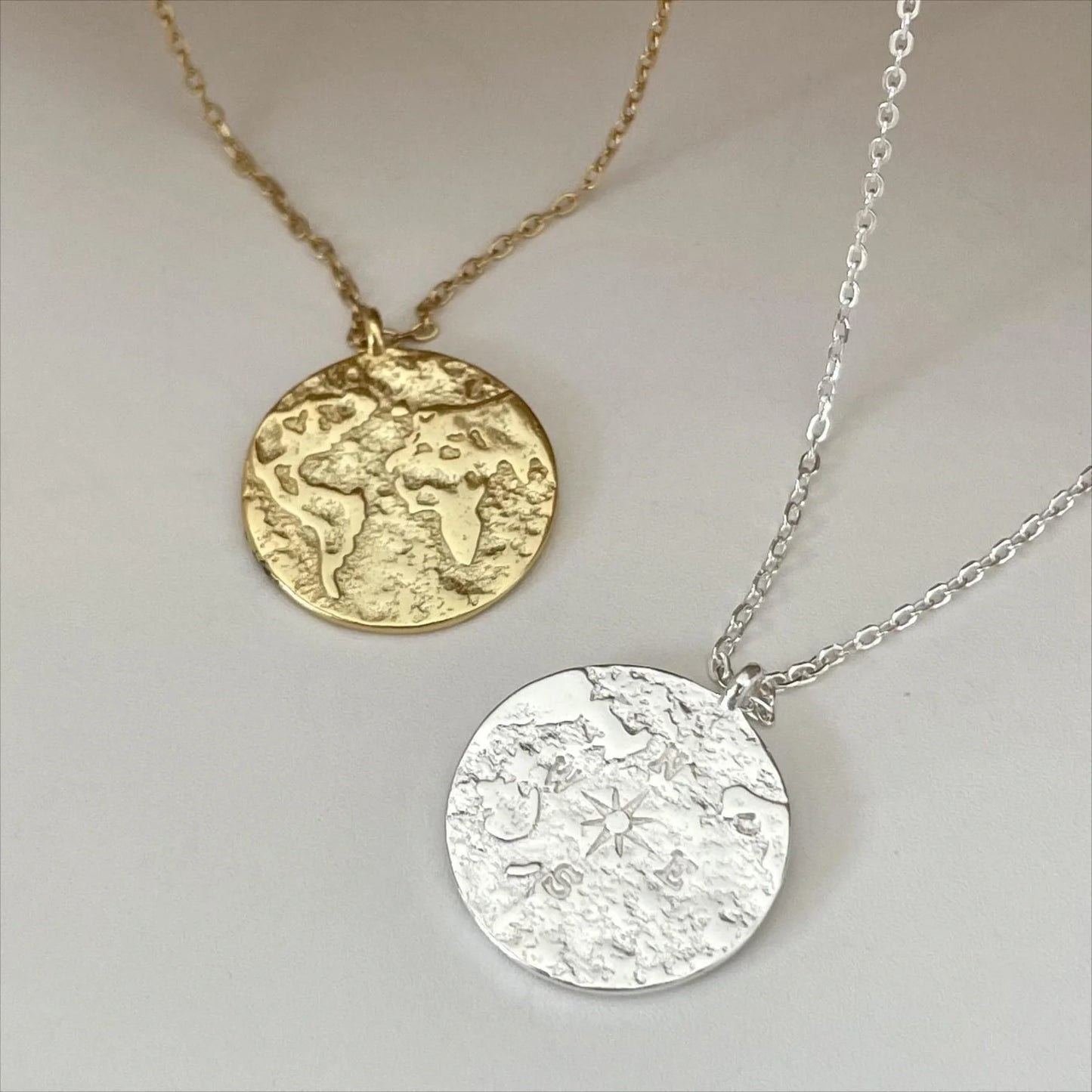 Deux colliers avec médaillons carte du monde, en finition or et argent. Collier atlas love local jewelry. Koolkado.