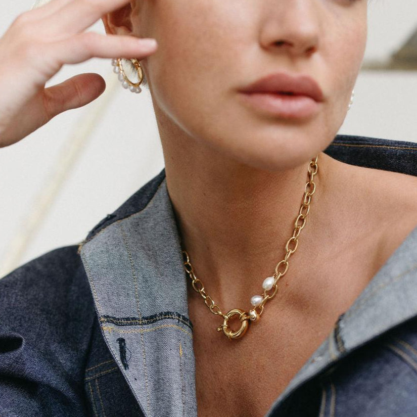 Gros plan sur un collier choker doré orné de perles baroques porté par une femme, bijou raffiné artisanal, idée cadeau femme ou ado.