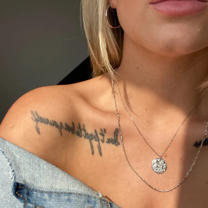 Collier BĂ©lier en argent portĂ© avec une autre chaĂźne fine sur les Ă©paules dĂ©nudĂ©es dâune femme blonde. IdĂ©e cadeau femme.