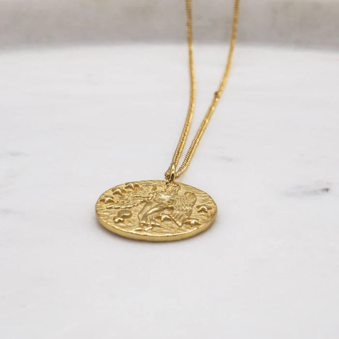 Collier zodiaque Vierge doré posé sur marbre, détails en relief visibles. Idée cadeau femme ou ado.