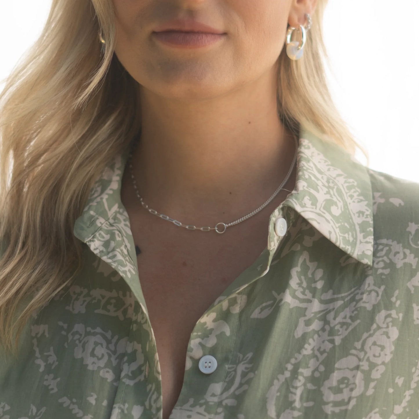 Femme avec collier Dua Choker argenté, chemise verte à motifs floraux. Idée cadeau