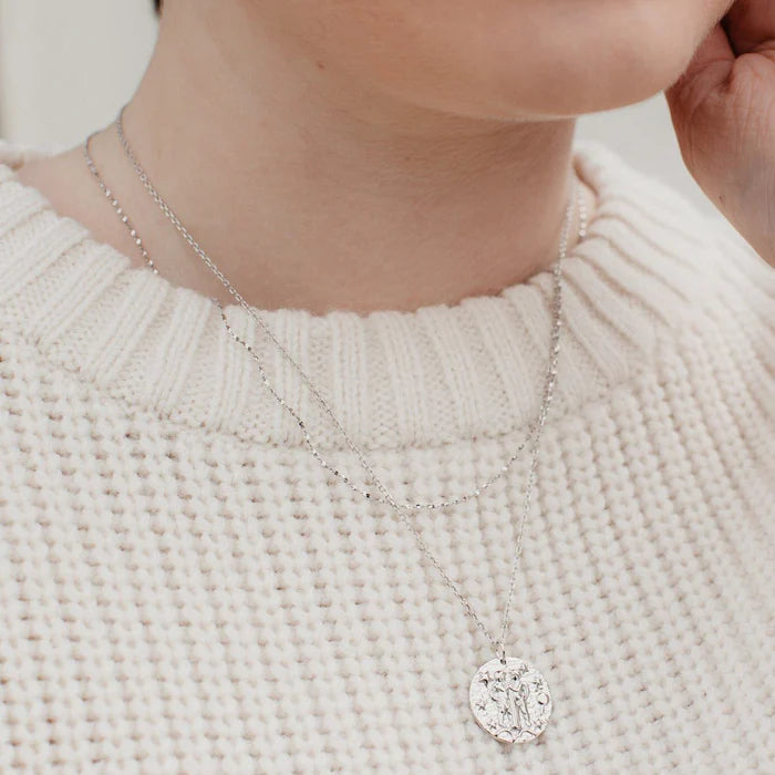 Collier en argent sterling avec pendentif zodiaque Gémeaux représentant deux personnages enlacés sur fond étoilé, idée cadeau femme.