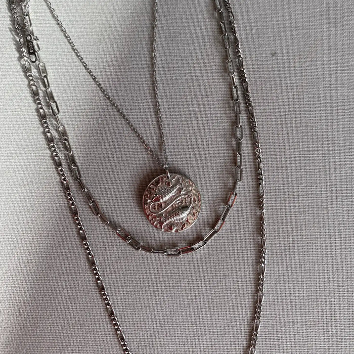 Collier Poissons en rhodium porté avec d'autres chaßnes argentées. Idée cadeau femme.