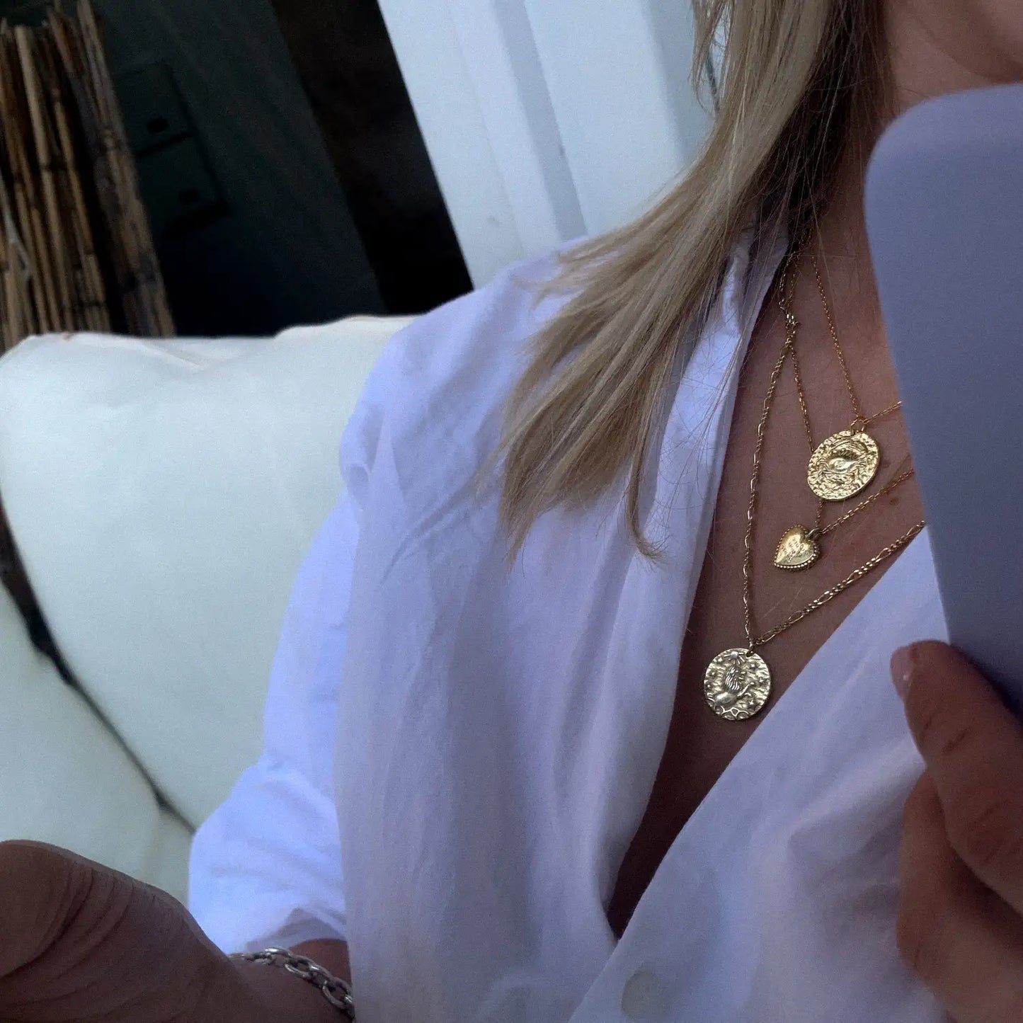 Femme portant un collier Cancer en superposition avec autres pendentifs dorés. Idée cadeau femme ou ado.