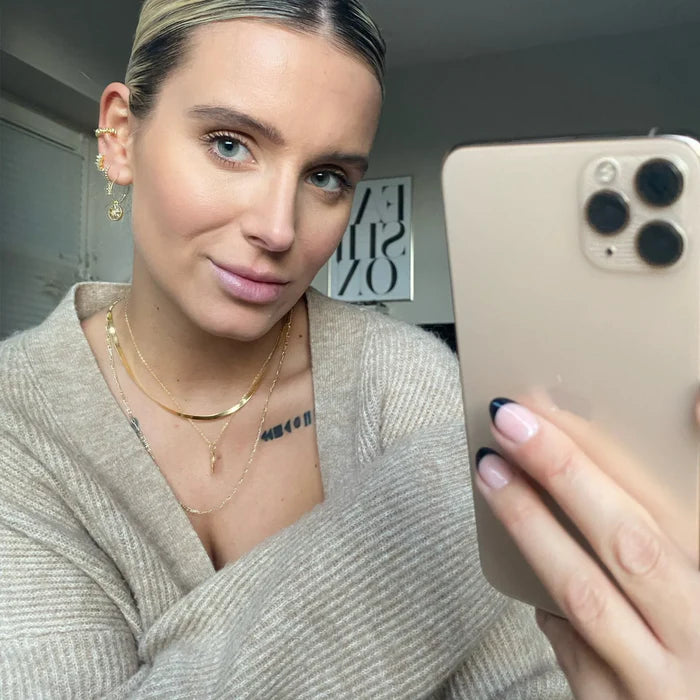Selfie d'une femme avec accumulation de colliers dorés dont un snake chain. Idée cadeau femme.