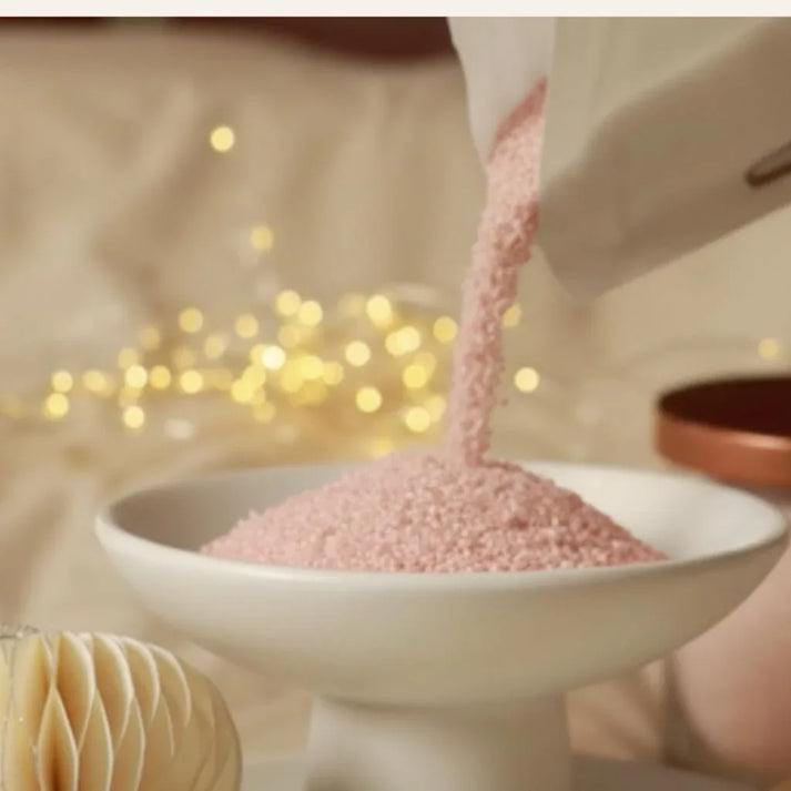 Versement de sable parfumé rose pour créer une bougie lors d’un rituel apaisant, geste créatif et élégant pour composer une ambiance douce à la maison – KoolKado