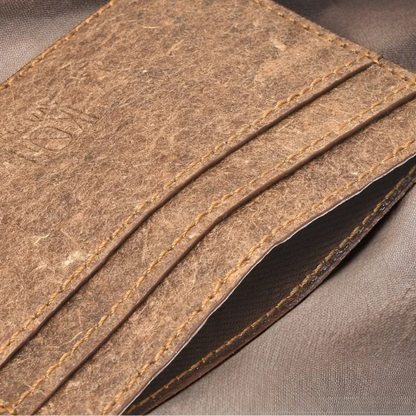 Gros plan du porte-cartes slim IKON Sweden en cuir végétal de noix de coco, finition marron naturelle avec coutures apparentes et texture artisanale.