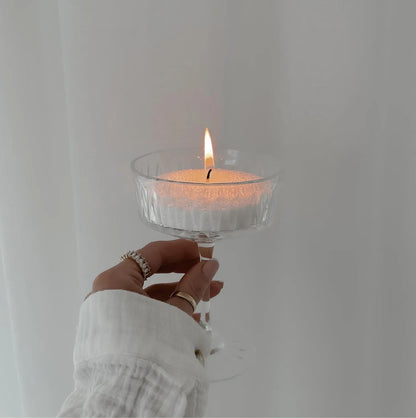 Bougie parfumée allumée tenue à la main pour une ambiance lifestyle chaleureuse