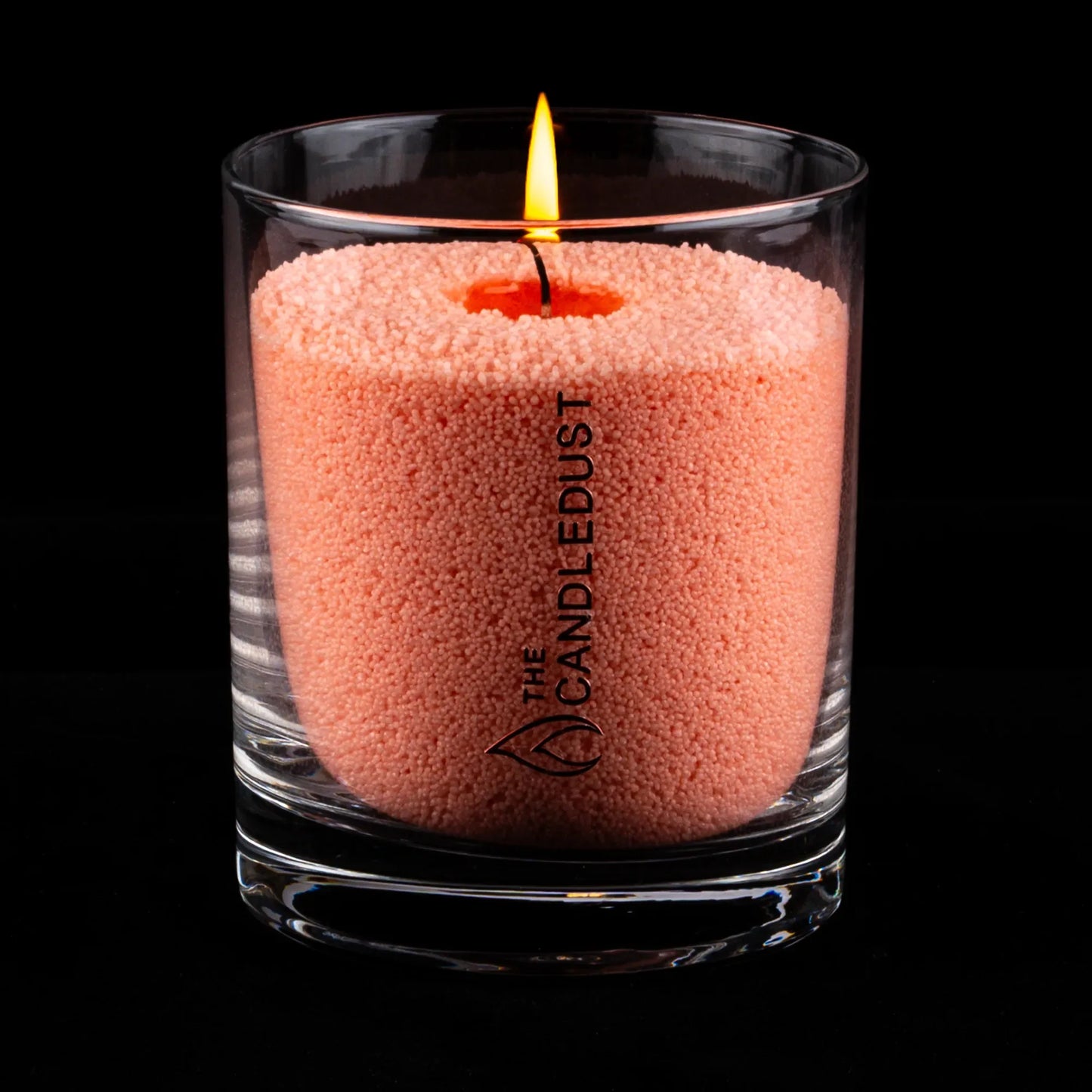 Bougie de rituel parfumé en sable rose dans un verre transparent, allumée et présentée sur fond sombre, idée cadeau élégante pour créer une ambiance douce à la maison – KoolKado