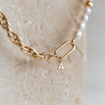 Bracelet doré avec maillons et perles blanches, fermoir mousqueton orné d’une lettre A en plaqué or 24K, bijou personnalisable fait main.