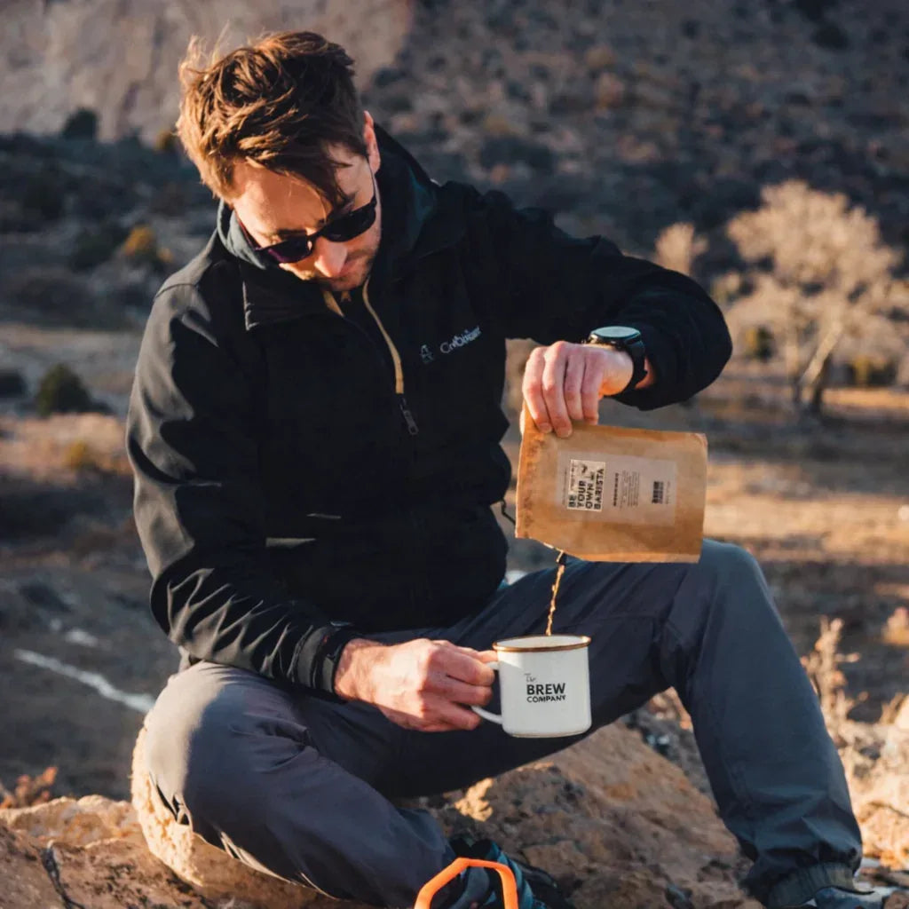 Homme préparant un café en plein air avec un mug émaillé, idée cadeau pour amateur d’aventure idéale pour un anniversaire ou Noël – KoolKado