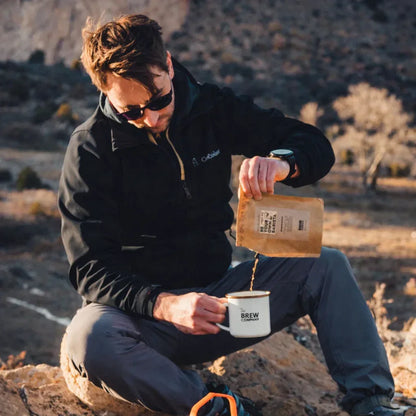 Homme préparant un café en plein air avec un mug émaillé, idée cadeau pour amateur d’aventure idéale pour un anniversaire ou Noël – KoolKado