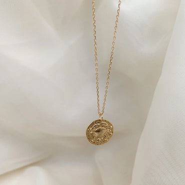 Collier Cancer en plaqué or suspendu sur tissu blanc, ambiance douce et poétique. Idée cadeau femme ou ado.