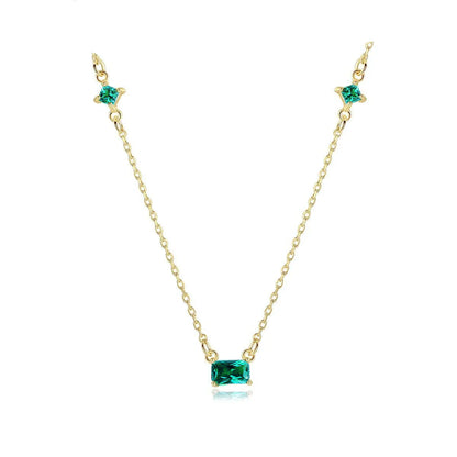 Collier doré avec pierre émeraude rectangulaire et deux petites pierres vertes, sur fond blanc. Idée cadeau femme. Koolkado.
