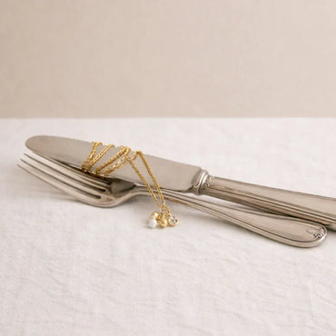 Collier fin Carla délicatement posé dans une mise en scène poétique, idée cadeau artisanale faite main en France pour une attention élégante – KoolKado
