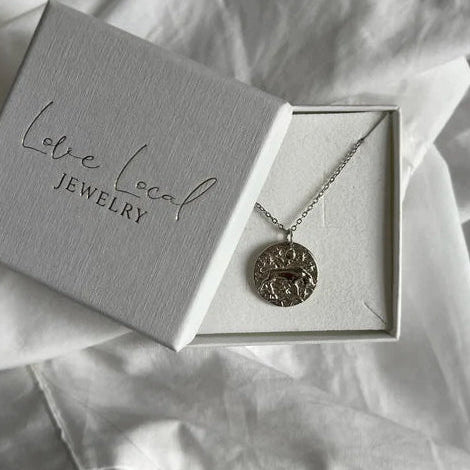 Idée cadeau pour Taureau : Collier astro or argent dans son écrin cadeau, vue de haut.