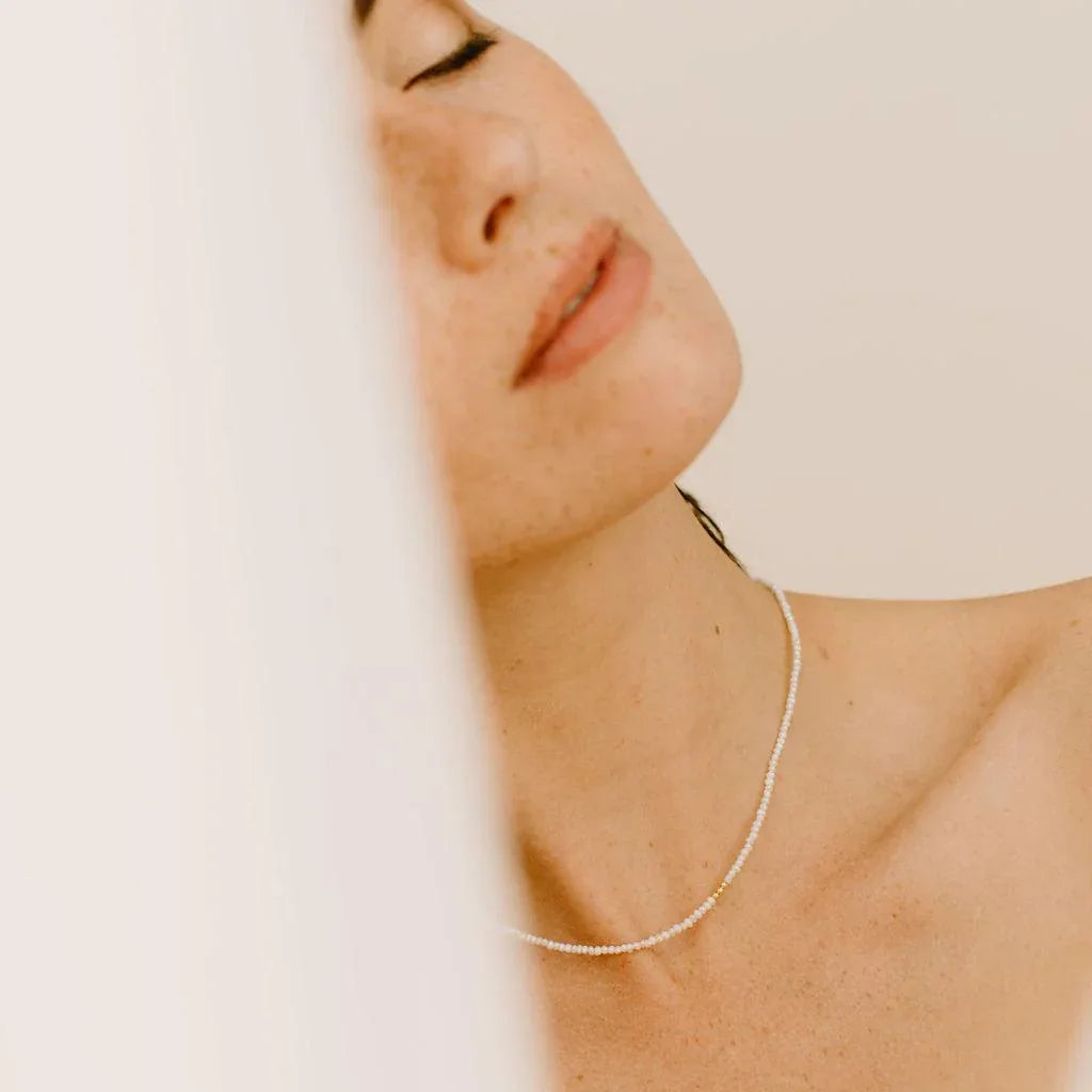 Idées cadeaux collier perles et doré porté par une femme, bijou élégant et intemporel à offrir