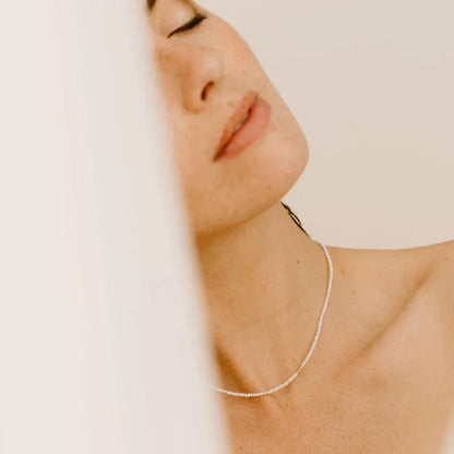 Idées cadeaux collier perles et doré porté par une femme, bijou élégant et intemporel à offrir