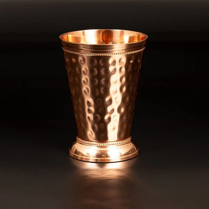 Gros plan d un gobelet en cuivre pur Valia montrant son relief de style romain forge a la main et sa structure architecturale unique