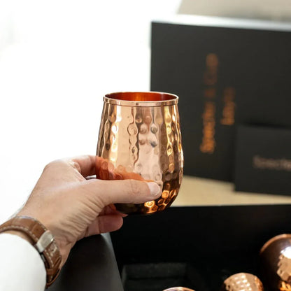Gros plan d un gobelet en cuivre massif Layla tenu en main soulignant sa structure massive et sa finition marteler artisanale
