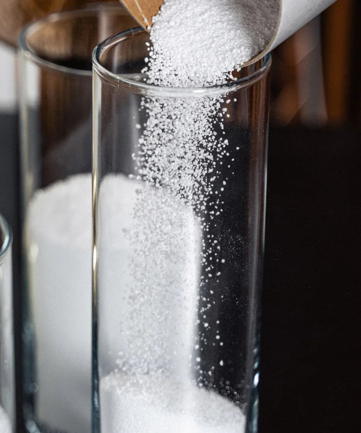 Granulés de cire versés dans un verre pour la fabrication d’une bougie parfumée