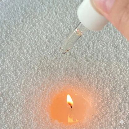 Ajout de quelques gouttes d’huile parfumée d’intérieur à la lavande dans une bougie, idée cadeau parfaite pour accompagner un moment de calme et de détente – KoolKado