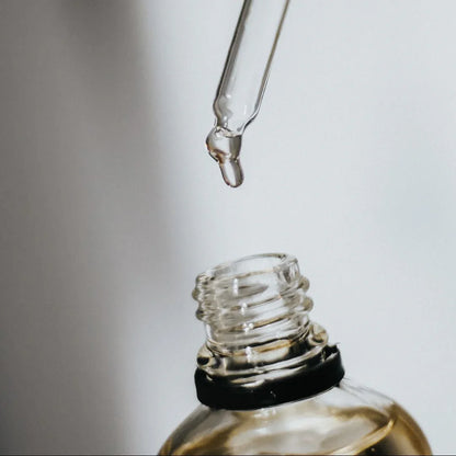 Ajout de quelques gouttes d’huile parfumée d’intérieur dans une bougie, idée cadeau élégante pour accompagner les moments cosy – KoolKado