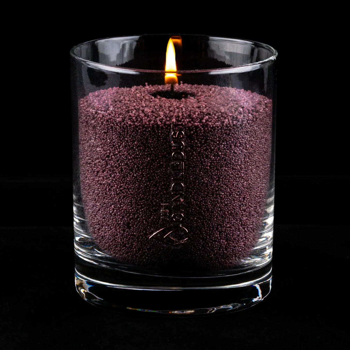 Idées cadeaux bougie décorative Candledust allumée, couleur lilas foncé, parfaite pour créer une ambiance chic et feutrée à la maison.