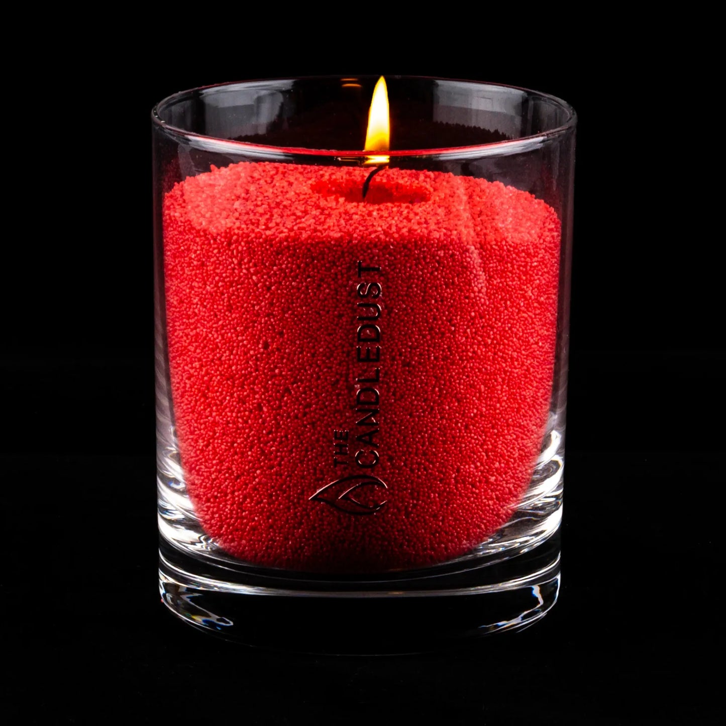 Idées cadeaux bougie décorative Candledust allumée, couleur sable rouge, parfaite pour créer une ambiance conviviale et raffinée à la maison.