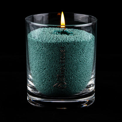 Idées cadeaux bougie décorative Candledust allumée, couleur vert émeraude, parfaite pour créer une ambiance chic et apaisante à la maison.