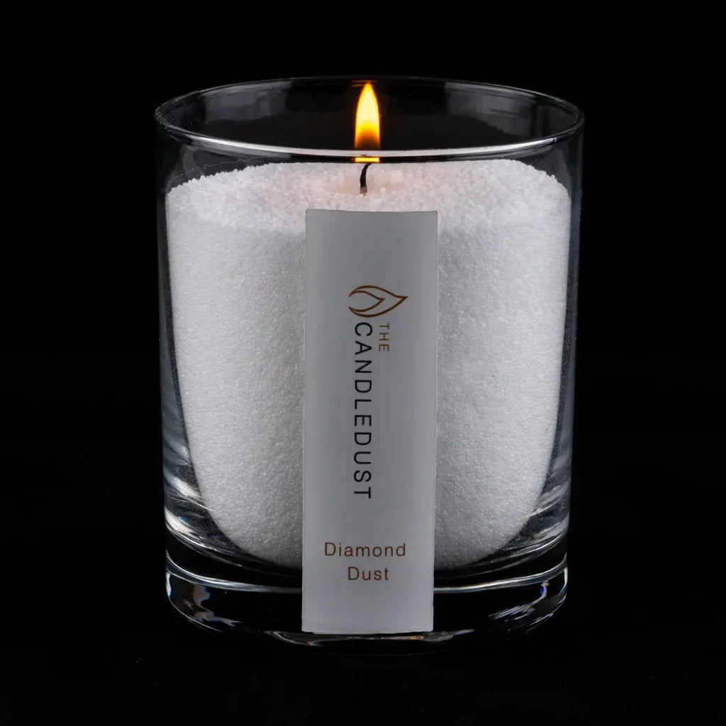 Idées cadeaux pour adulte : bougie parfumée Diamond Dust Candledust allumée, mise en valeur sur fond sombre pour souligner ses notes épicées et boisées
