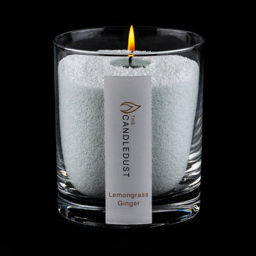 Idées cadeaux pour adulte : bougie parfumée Lemongrass Ginger Candledust allumée, mise en valeur sur fond sombre élégant