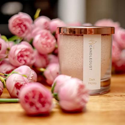 Idées cadeaux pour adulte : bougie parfumée Pomegranate Spice Candledust mise en scène dans une ambiance florale raffinée