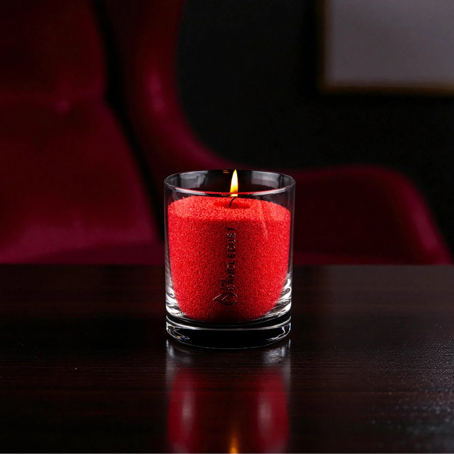 Idées cadeaux avec bougie en sable rouge créant une ambiance chaleureuse, idéale pour offrir un moment élégant et intime.