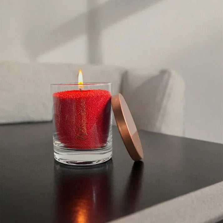 Idées cadeaux avec bougie en sable rouge diffusant une lumière douce, parfaite pour offrir une ambiance chaleureuse.