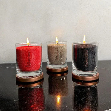 Idées cadeaux bougies décoratives en verre Candledust, couleurs sable, rouge et anthracite, idéales pour une décoration de maison élégante.