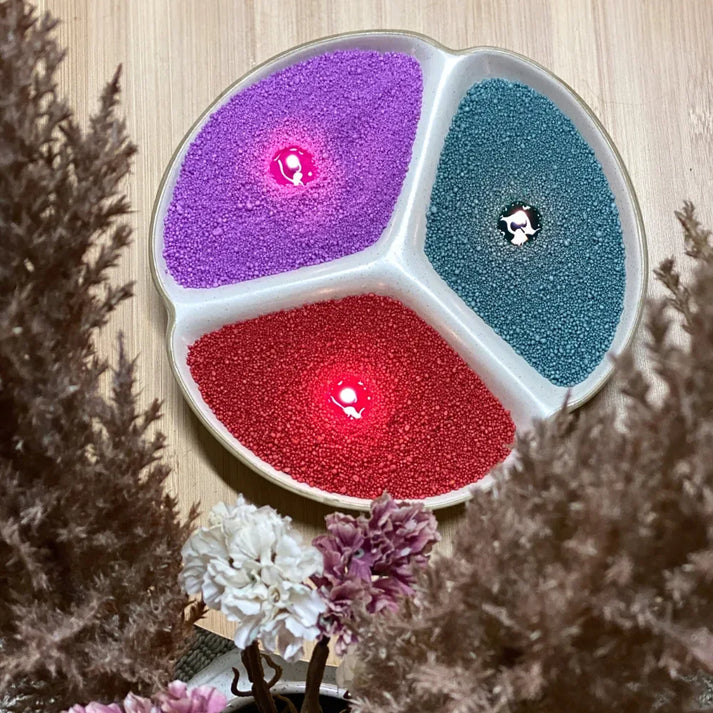 Idées cadeaux avec bougies en sable multicolores disposées dans un contenant, idéales pour offrir une création décorative originale.