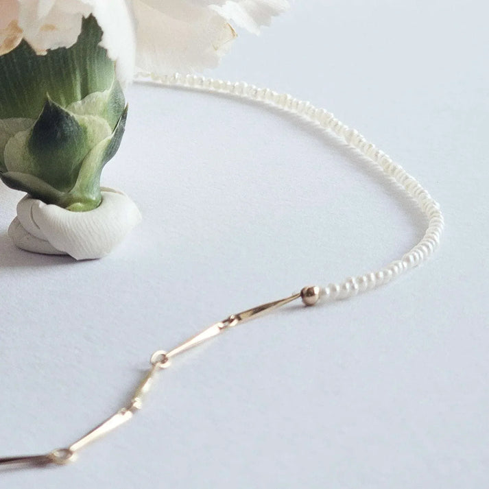 Idées cadeaux bijoux femme : détail du collier bi-matière en perles de culture fines et mailles bâtons design