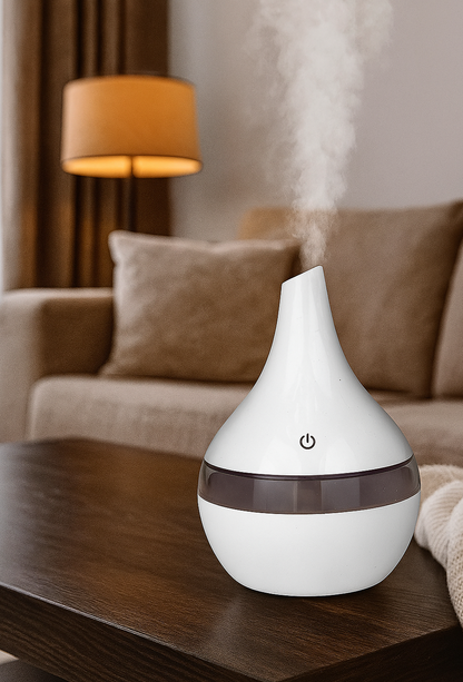 Idées cadeaux pour adulte – diffuseur d’huiles essentielles blanc dans un salon cosy, parfait pour créer une ambiance relax et purifier l’air. Koolkaodo