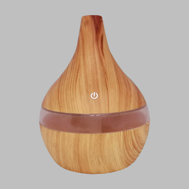 Idées cadeaux pour femme : diffuseur d'huiles essentielles design bois clair sur fond neutre, parfait pour un intérieur zen et élégant