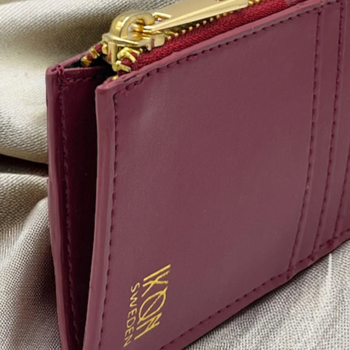 Vue de profil d’un porte-cartes zippé bordeaux en cuir végétal avec rangements intérieurs, format compact et pratique, idée cadeau élégante – KoolKado