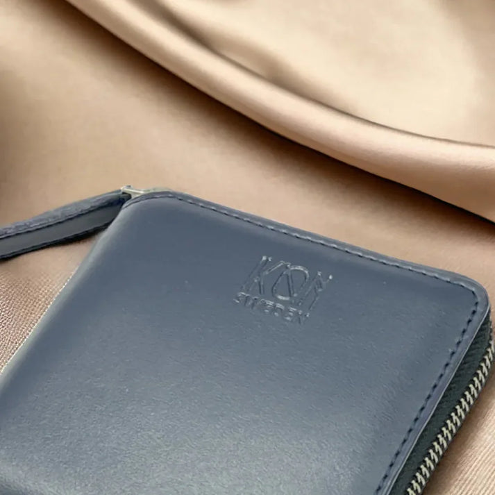Détail de la texture d’un porte-cartes zippé bleu en cuir végétal, finitions soignées et design épuré, idée cadeau élégante – KoolKado