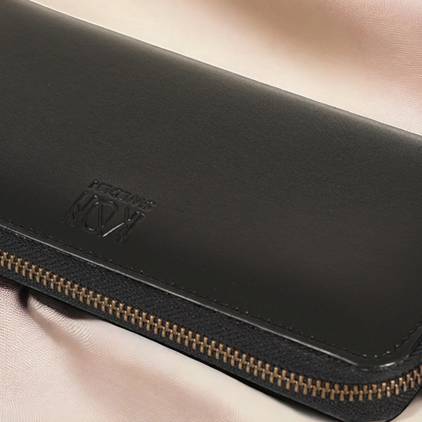 Détail extérieur d’un portefeuille long zippé en cuir végétal noir avec logo embossé et fermeture zippée, finition élégante et soignée, idée cadeau premium – KoolKado